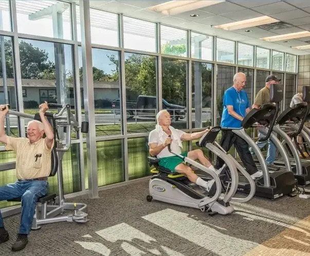 A group of men in the gym doing different exercises.