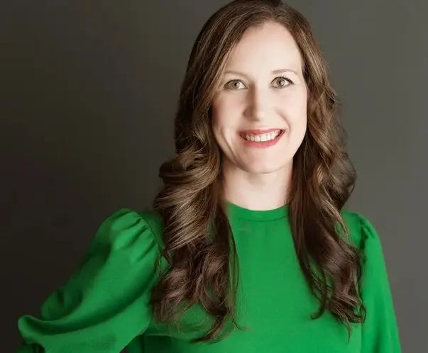 A woman in green shirt smiling for the camera.