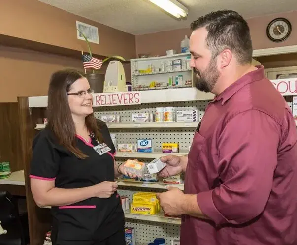 A woman and man talking in a pharmacy.