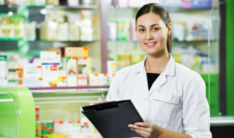 A woman holding a clipboard in front of shelves.