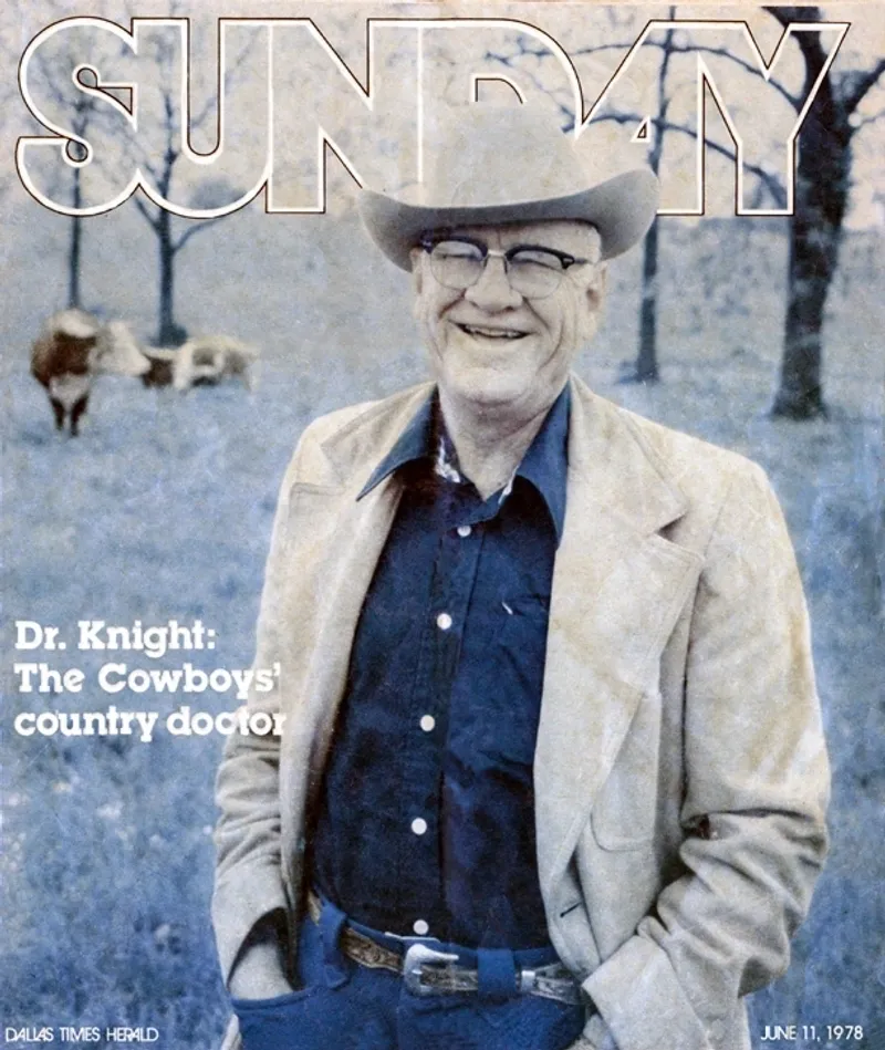 A man in cowboy clothes standing next to cows.